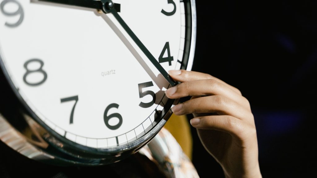 female hand moving the hand on a clock